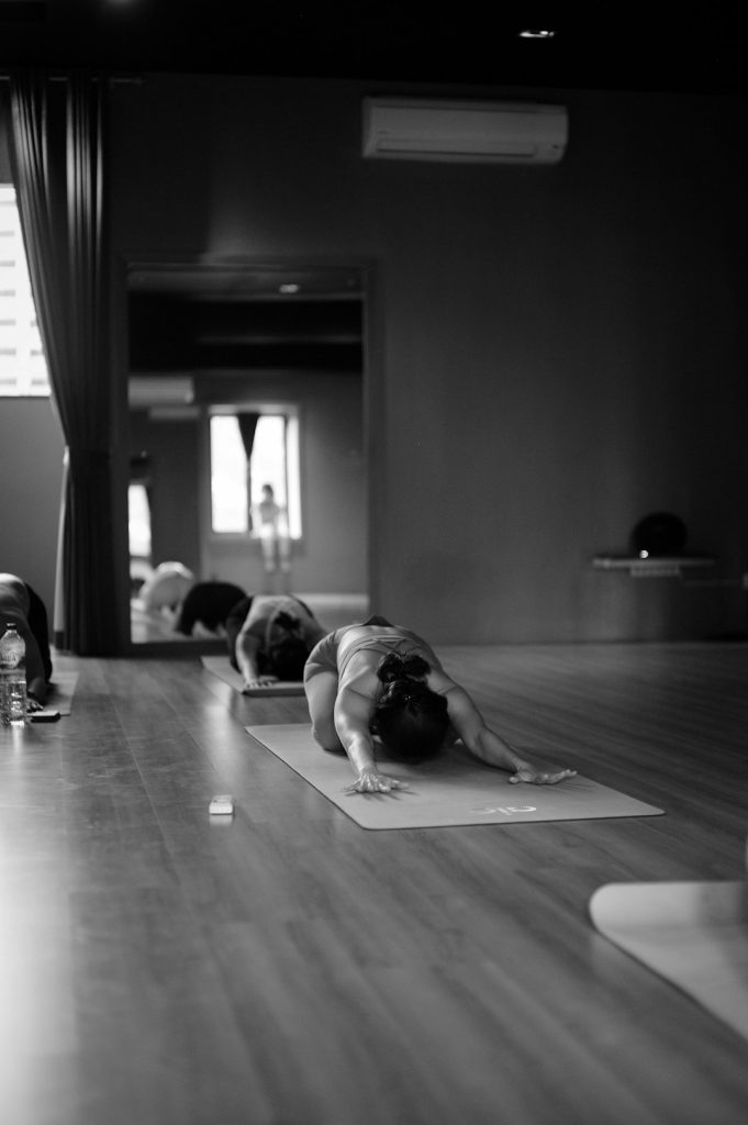 a-group-of-people-doing-yoga-in-a-room-tsn7bhcwfxq