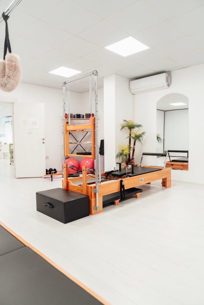 Bright and modern white Pilates studio interior equipped with a Pilates tower.